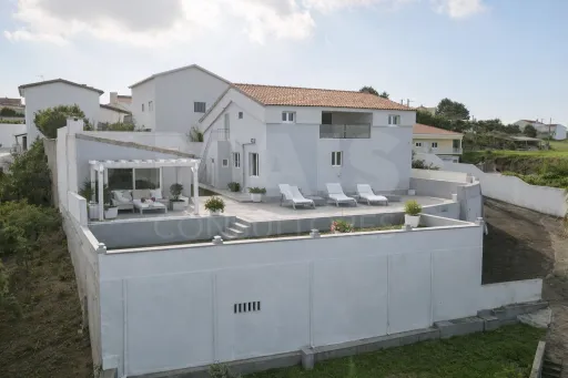 Moradia com duas habitações independentes, terreno e grande potencial de investimento junto à Praia da Areia Branca.