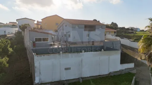 Moradia com duas habitações independentes, terreno e grande potencial de investimento junto à Praia da Areia Branca.