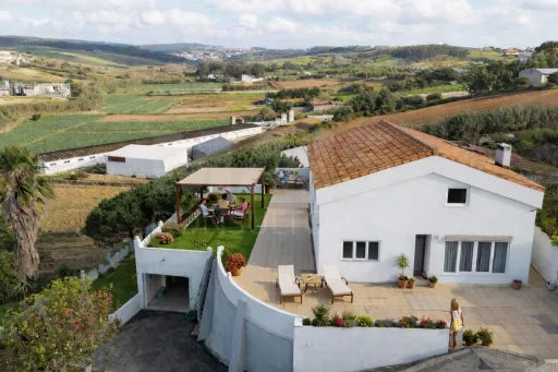 Moradia com duas habitações independentes, terreno e grande potencial de investimento junto à Praia da Areia Branca.