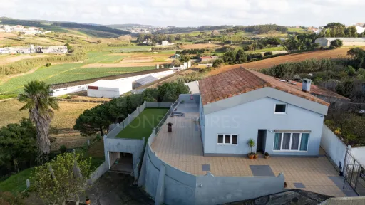 Moradia com duas habitações independentes, terreno e grande potencial de investimento junto à Praia da Areia Branca.